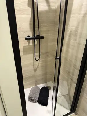 a shower with a glass door and two towels at Goldie's Retreat in Blackrod
