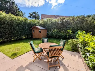 a patio with a table and chairs in a yard at Cosy Single Room l Smart TV l 5 Minute Walk from Train Station in Bolton