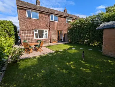 a house with a yard with chairs and a table at Cosy Single Room l Smart TV l 5 Minute Walk from Train Station in Bolton