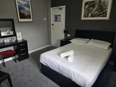 a bedroom with a bed with two towels on it at Peek-a-Booze - Budget Hotel - Adults Only in Blackpool