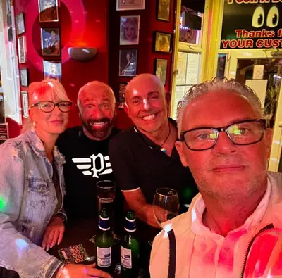 a group of people posing for a picture in a bar at Peek-a-Booze - Budget Hotel - Adults Only in Blackpool