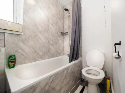 a bathroom with a white tub and a toilet at 3BR Haven Retreat in Wallasey with FREE Street Parking in Wallasey