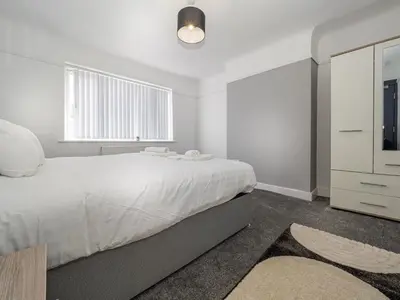 a white bedroom with a large bed and a window at 3BR Haven Retreat in Wallasey with FREE Street Parking in Wallasey