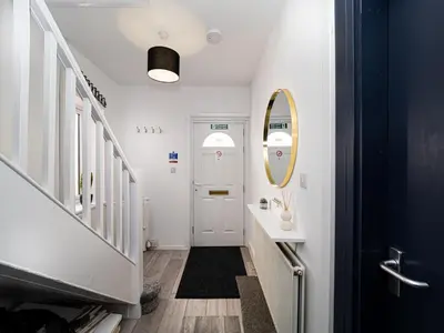 a hallway with a white door and a mirror at 3BR Haven Retreat in Wallasey with FREE Street Parking in Wallasey
