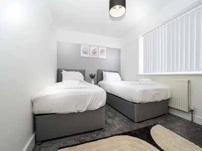 two beds in a small room with white walls at 3BR Haven Retreat in Wallasey with FREE Street Parking in Wallasey