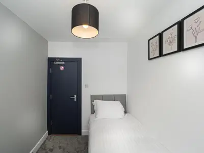 a bedroom with a bed and a black door at 3BR Haven Retreat in Wallasey with FREE Street Parking in Wallasey