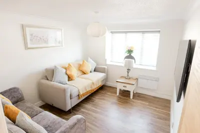 a living room with a couch and a chair at Stylish Modern Apartment in Blackpool with Parking in Blackpool