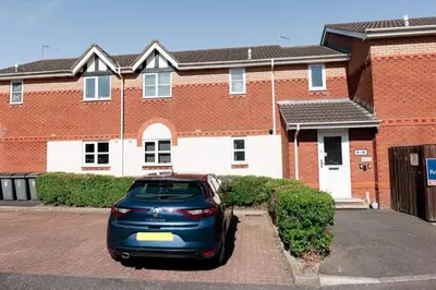 a blue car parked in front of a brick building at Stylish Modern Apartment in Blackpool with Parking in Blackpool