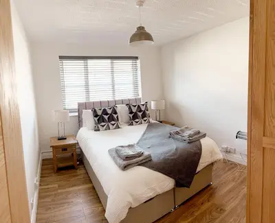 a bedroom with a bed with two towels on it at Stylish Modern Apartment in Blackpool with Parking in Blackpool