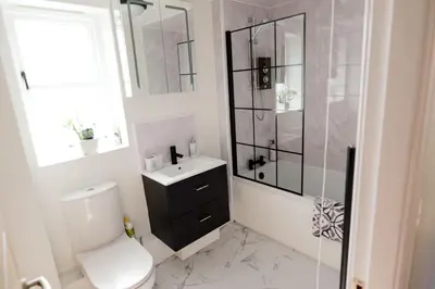 a white bathroom with a toilet and a shower at Stylish Modern Apartment in Blackpool with Parking in Blackpool