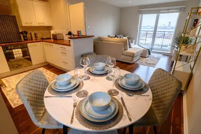 a dining room table with chairs and a kitchen at Stunning Liverpool City Location with River View and parking space included in Liverpool
