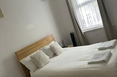 a bedroom with a bed with two pillows and a window at Seaside - House - Sleeps 10 - Parking - Garden in Blackpool
