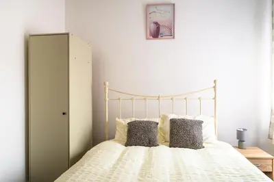 a bedroom with a white bed with two pillows at Seaside - House - Sleeps 10 - Parking - Garden in Blackpool