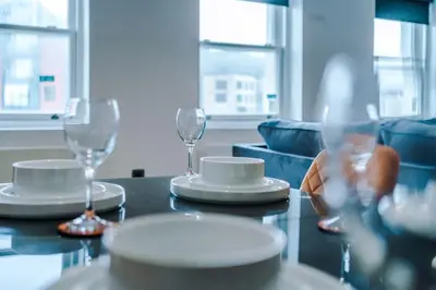 a table with two wine glasses and plates on it at #6 - Vibrant apartment in City Centre - Sleeps 7 - Exclusive offers at a-kapartments in Liverpool