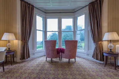 a room with two chairs and a large window at Cumbria Grand Hotel in Grange Over Sands