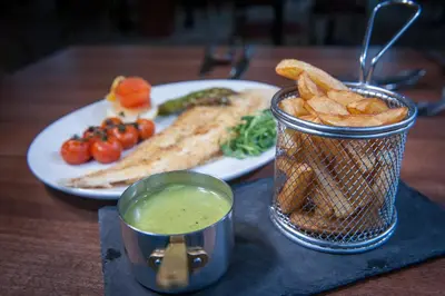 a table with a plate of food with french fries and dip at Cumbria Grand Hotel in Grange Over Sands