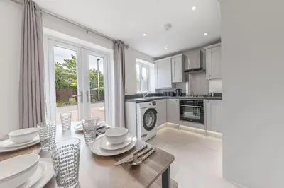 a kitchen with a table with plates and dishes on it at Barrow Central 3 Bedroom House in Roose