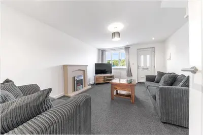 a living room with two couches and a tv at Barrow Central 3 Bedroom House in Roose