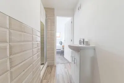 a white bathroom with a sink and a mirror at Barrow Central 3 Bedroom House in Roose