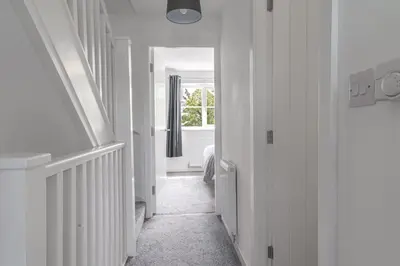 a hallway with white walls and a window in a room at Barrow Central 3 Bedroom House in Roose