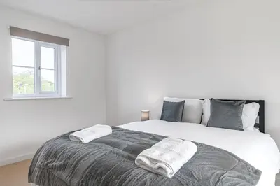 a white bedroom with a large bed with a window at Barrow- 4 bedroom Detached House in Roose