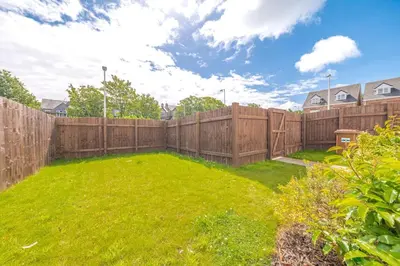 a backyard with a wooden fence and a green yard at Barrow- 4 bedroom Detached House in Roose