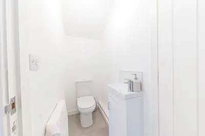 a white bathroom with a toilet and a sink at Barrow- 4 bedroom Detached House in Roose