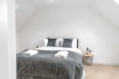 a white bedroom with a large bed with two pillows at Barrow- 4 bedroom Detached House in Roose