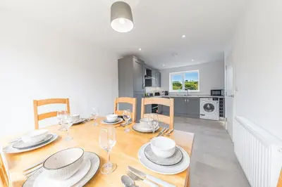 a dining room and kitchen with a table and chairs at Barrow- 4 bedroom Detached House in Roose