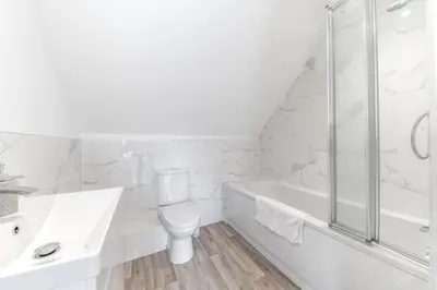 a white bathroom with a toilet and a shower at Barrow- 4 bedroom Detached House in Roose