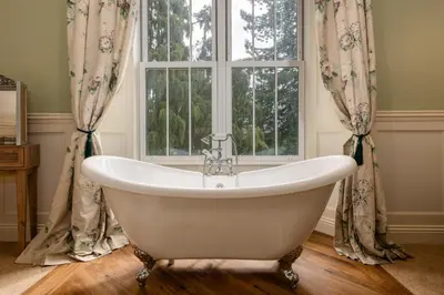 a bath tub in a bathroom with a window at Grange Manor in Grange Over Sands