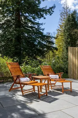 two picnic tables and two chairs on a patio at Grange Manor in Grange Over Sands