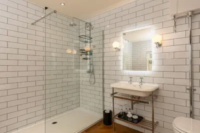 a bathroom with a tub and a sink and a shower at Grange Manor in Grange Over Sands