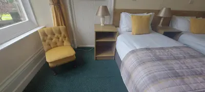 a hotel room with a bed and a chair at Ashton Hall at Lancaster Golf Club in Lancaster