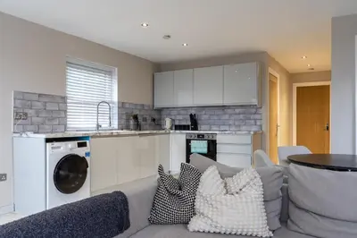 a living room with a couch and a kitchen at The Slipway Cabins with Hottub in Burscough
