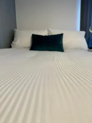 a black pillow sitting on top of a bed at 2 Bed Apartment Scarisbrick Street Ormskirk - Rooms by Vici in Ormskirk