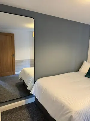 a bedroom with a mirror next to a bed at 2 Bed Apartment Scarisbrick Street Ormskirk - Rooms by Vici in Ormskirk