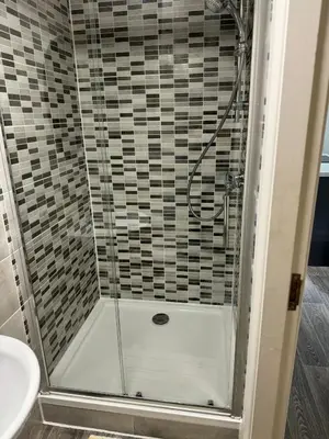 a shower with a glass door in a bathroom at 2 Bed Apartment Scarisbrick Street Ormskirk - Rooms by Vici in Ormskirk