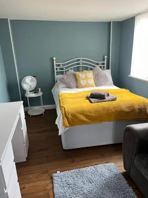 a bedroom with a bed with a yellow blanket at Birkdale's Hidden Gem in Southport
