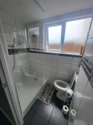 a bathroom with a toilet and a shower and a sink at Birkdale's Hidden Gem in Southport