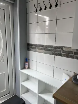 a bathroom with white tiled walls and white shelves at Birkdale's Hidden Gem in Southport