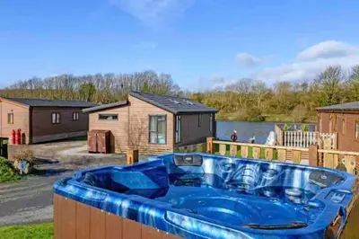 a large blue tub in a yard with a house at Driftwood Lodge - South Lakeland Leisure Village in Carnforth