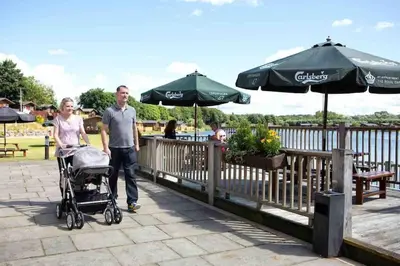 a man and a woman walking with a stroller at Driftwood Lodge - South Lakeland Leisure Village in Carnforth