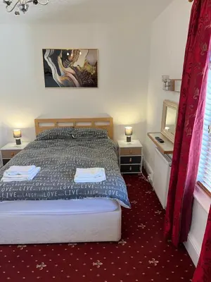 a bedroom with a bed and two tables and a tv at Marston town centre villa in Blackpool