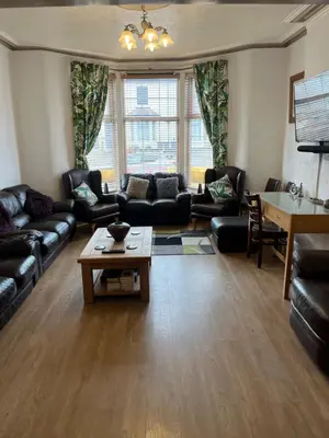 a living room with leather couches and a table at Marston town centre villa in Blackpool