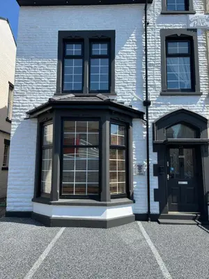 a building with a black door and windows at Marston town centre villa in Blackpool
