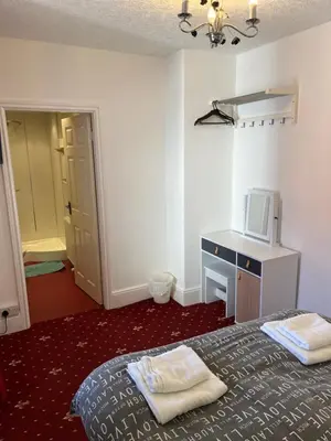 a bedroom with a bed and a desk with a microwave at Marston town centre villa in Blackpool
