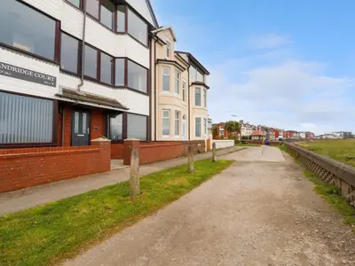 an empty street in front of a building at Flat 1, Sandridge Court in Knott End-on-Sea