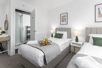 a bedroom with two beds and a table with fruit on a tray at The Wavertree Rooms - Air Host & Stay - 6 Bedrooms in Liverpool
