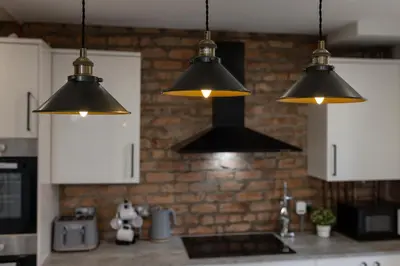 a kitchen with three lights hanging over a counter at The Wavertree Rooms - Air Host & Stay - 6 Bedrooms in Liverpool